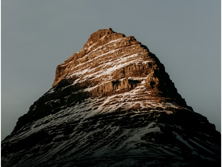 A mountaintop at sunset with both shadows and bright light bathing it